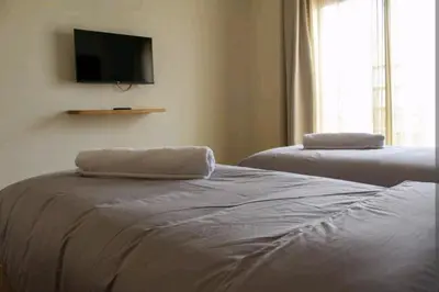 a bedroom with two beds and a tv on the wall at COSY APPART avec 2 piscines, 2 CH, 2 SDB Marrakech in Marrakech