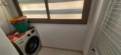 a washing machine in a room with a window at COSY APPART avec 2 piscines, 2 CH, 2 SDB Marrakech in Marrakech