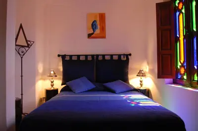 a bedroom with a bed with a stained glass window at Riad Aubrac in Marrakech