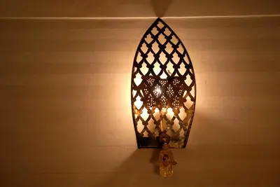 a light hanging on a wall with a clock at Riad Aubrac in Marrakech