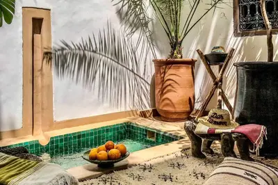 a room with a pool with a bowl of fruit at Riad Dar Zaman in Marrakech