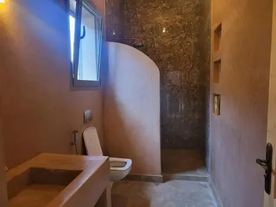 a bathroom with a toilet and a window at Dar Sofia Villa in Marrakech