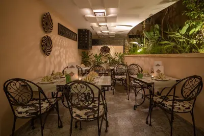 a dining room with tables and chairs and plants at Dellarosa Boutique Hotel and Spa in Marrakech