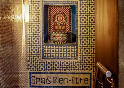 a bathroom with a mosaic tile wall with a mirror at Dellarosa Boutique Hotel and Spa in Marrakech