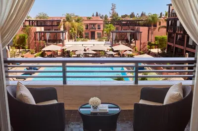 a view of a pool from the balcony of a hotel at Hôtel & Ryads Barrière Le Naoura in Marrakech