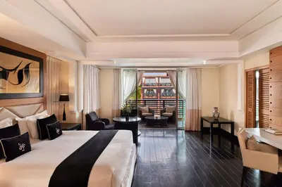 a hotel room with a bed and a living room at Hôtel & Ryads Barrière Le Naoura in Marrakech