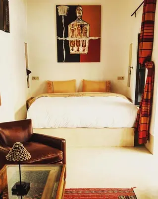 a bedroom with a bed and a chair in it at Riad Les 5 Soeurs in Marrakech