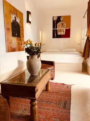 a room with a vase on a table and a bed at Riad Les 5 Soeurs in Marrakech