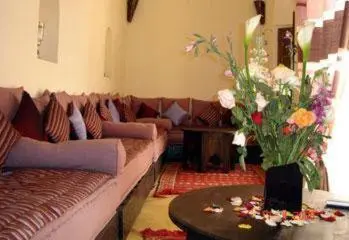 a living room with a couch and a vase of flowers at Riad Al Faras in Marrakech