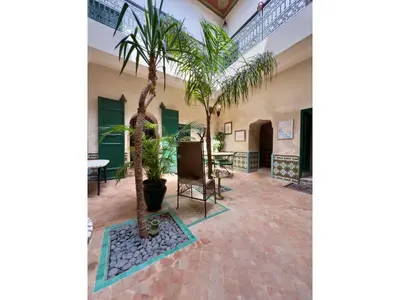 a hallway with palm trees in a building at Riad Al Karama in Marrakech
