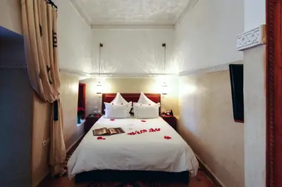 a bedroom with a white bed with red roses on it at Riad Dar Justo Hotel Boutique & Spa in Marrakech