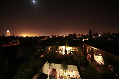 a view of a city at night with the moon at Riad Dar Justo Hotel Boutique & Spa in Marrakech