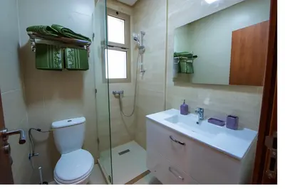 a bathroom with a shower and a toilet and a sink at Ehden Properties - Appt luxueux dans la residence golfique Prestigia Argan in Marrakech