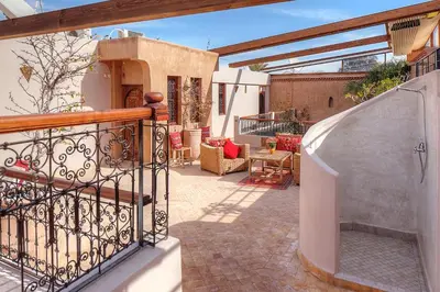 an outdoor patio with a staircase and a balcony at Riad Carina in Marrakech