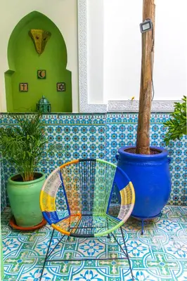 a table with a chair and a potted plant at Riad Med Agorà in Marrakech