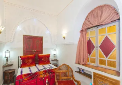a bedroom with a bed and a window at Riad Maison Arabo-Andalouse in Marrakech