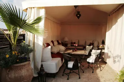 a living room with white furniture and a table and chairs at Riad Diana in Marrakech