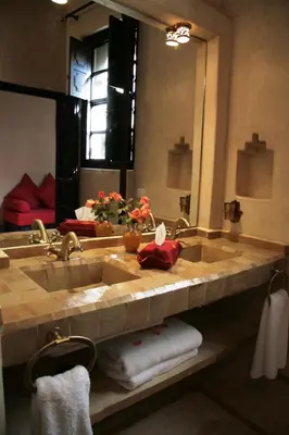 a bathroom with a sink and a large mirror at Riad Diana in Marrakech