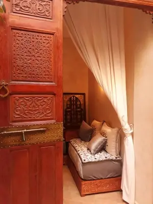 a room with a bed and a curtain and a door at Riad Dar Zaya in Marrakech