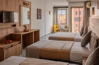 a hotel room with two beds and a television at Imperial Holiday Hôtel & spa in Marrakech