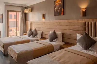a hotel room with three beds in a room at Imperial Holiday Hôtel & spa in Marrakech