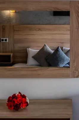 a shelf with a bunch of pillows and a bouquet of red flowers at Imperial Holiday Hôtel & spa in Marrakech