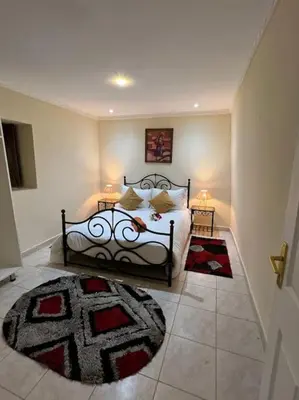 a bedroom with a bed with two lamps and a rug at Villa Oasis de la Palmeraie in Marrakech