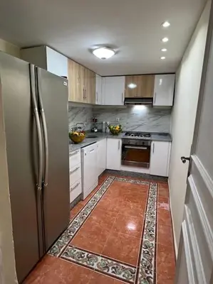 a kitchen with a stainless steel refrigerator and white cabinets at Villa Oasis de la Palmeraie in Marrakech