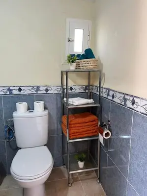 a bathroom with a toilet and a shelf with towels at Villa Oasis de la Palmeraie in Marrakech