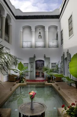 a courtyard with a pool in a building at Riad Les Hibiscus in Marrakech