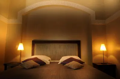 a bedroom with a large bed with two lamps at Riad Les Hibiscus in Marrakech