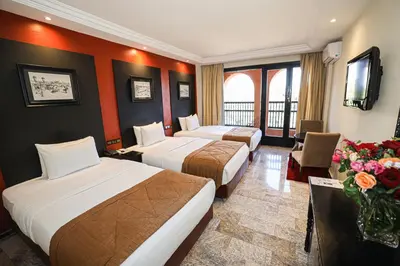 a hotel room with two beds and a television at El Andalous Lounge & Spa Hotel in Marrakech