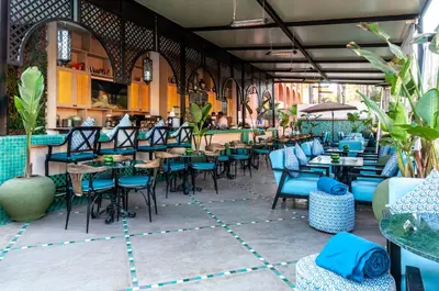 a restaurant with blue chairs and tables and a bar at El Andalous Lounge & Spa Hotel in Marrakech