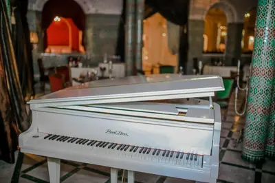 a white piano sitting inside of a room at The Red House in Marrakech