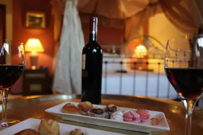 a table with a bottle of wine and a plate of donuts at The Red House in Marrakech