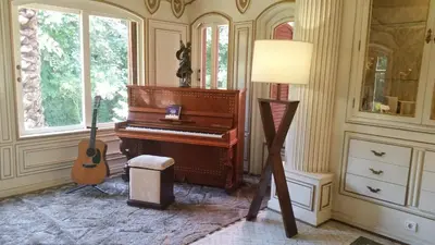a piano in a room with a guitar and a lamp at The Red House in Marrakech