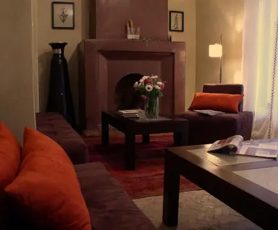 a living room with a couch and a table with a fireplace at Riad Dar Selen in Marrakech