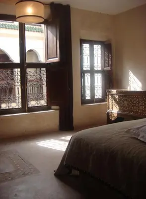 a bedroom with windows and a bed and a piano at Riad Dar Selen in Marrakech
