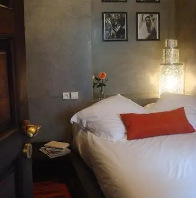 a bedroom with a white bed with a red pillow at Riad Dar Selen in Marrakech