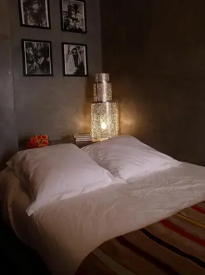 a bedroom with a white bed with a lamp on it at Riad Dar Selen in Marrakech