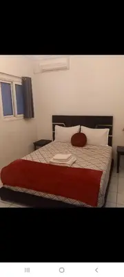 a bedroom with a large bed with a red blanket at Riad Al Nakhil in Marrakech