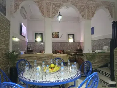 a table with a bowl of fruit on it in a restaurant at Riad Al Nakhil in Marrakech