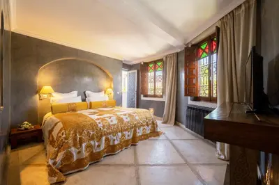 a bedroom with a bed and stained glass windows at Riad Alma in Marrakech