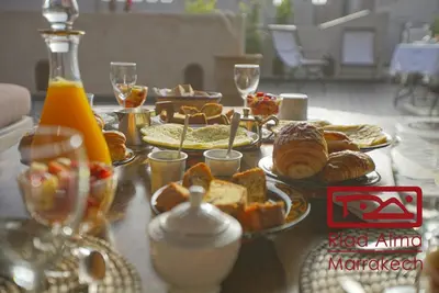 a table topped with plates of bread and pastries at Riad Alma in Marrakech