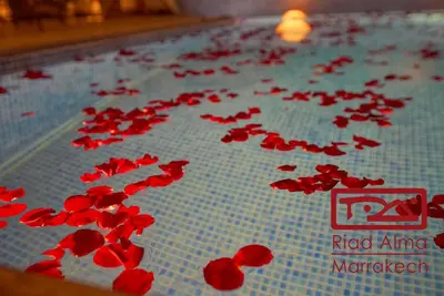 a bunch of red flowers on a table at Riad Alma in Marrakech