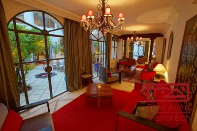 a living room with red furniture and a large window at Riad Alma in Marrakech