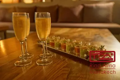 three champagne glasses on a table with a tray of fruit at Riad Alma in Marrakech