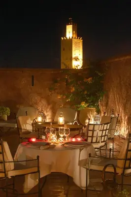 a table and chairs with a castle in the background at Riad Altair in Marrakech