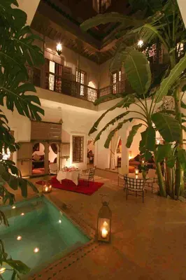 a large house with a swimming pool in a courtyard at Riad Altair in Marrakech