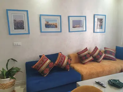 a living room with a blue couch with pillows at Bel appartement moderne au cœur de guelize in Marrakech
